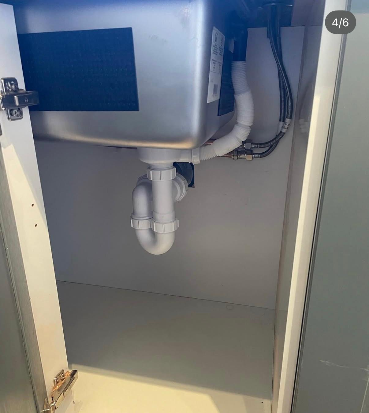Under-sink plumbing inspection during a leak detection visit by Coventry Plumbing Services