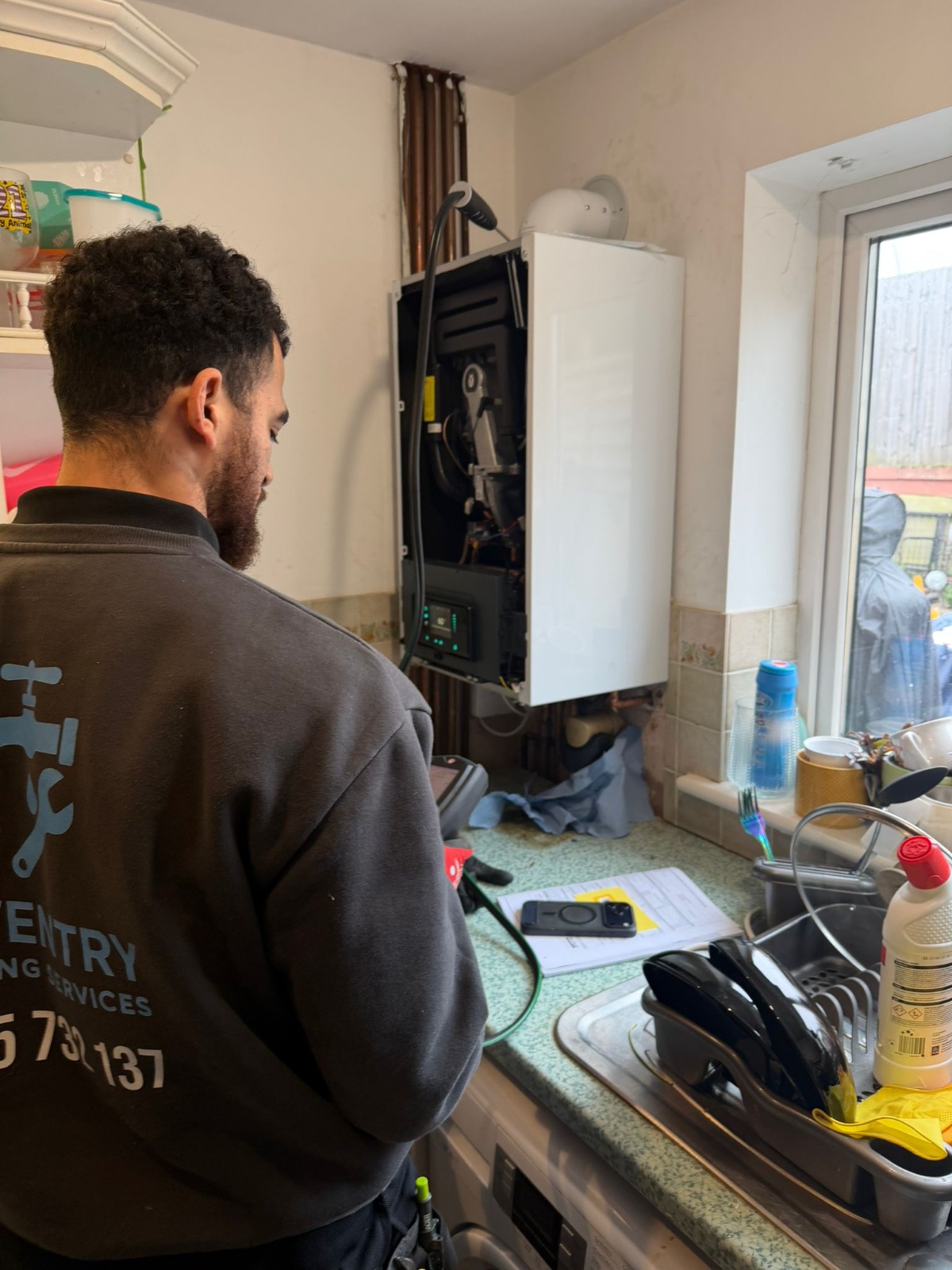Gas Safe engineer servicing a combi boiler during installation in Coventry