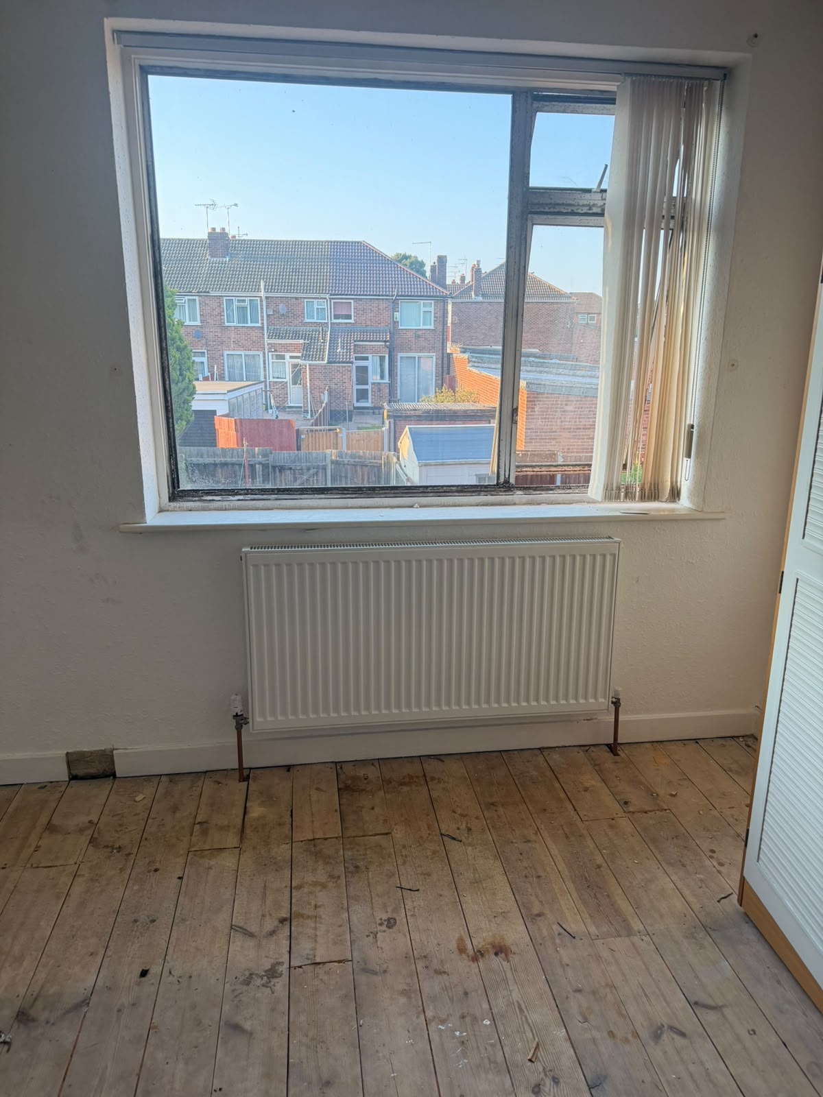 White panel radiator fitted below bedroom window on new copper heating pipework