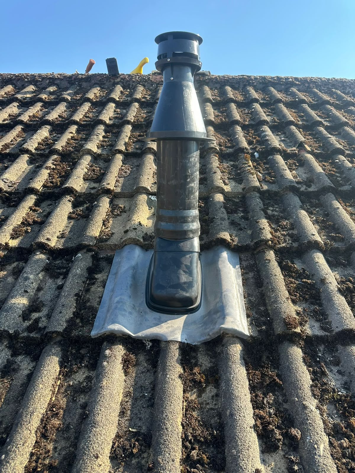 New boiler flue terminal correctly fitted through tiled roof with lead flashing