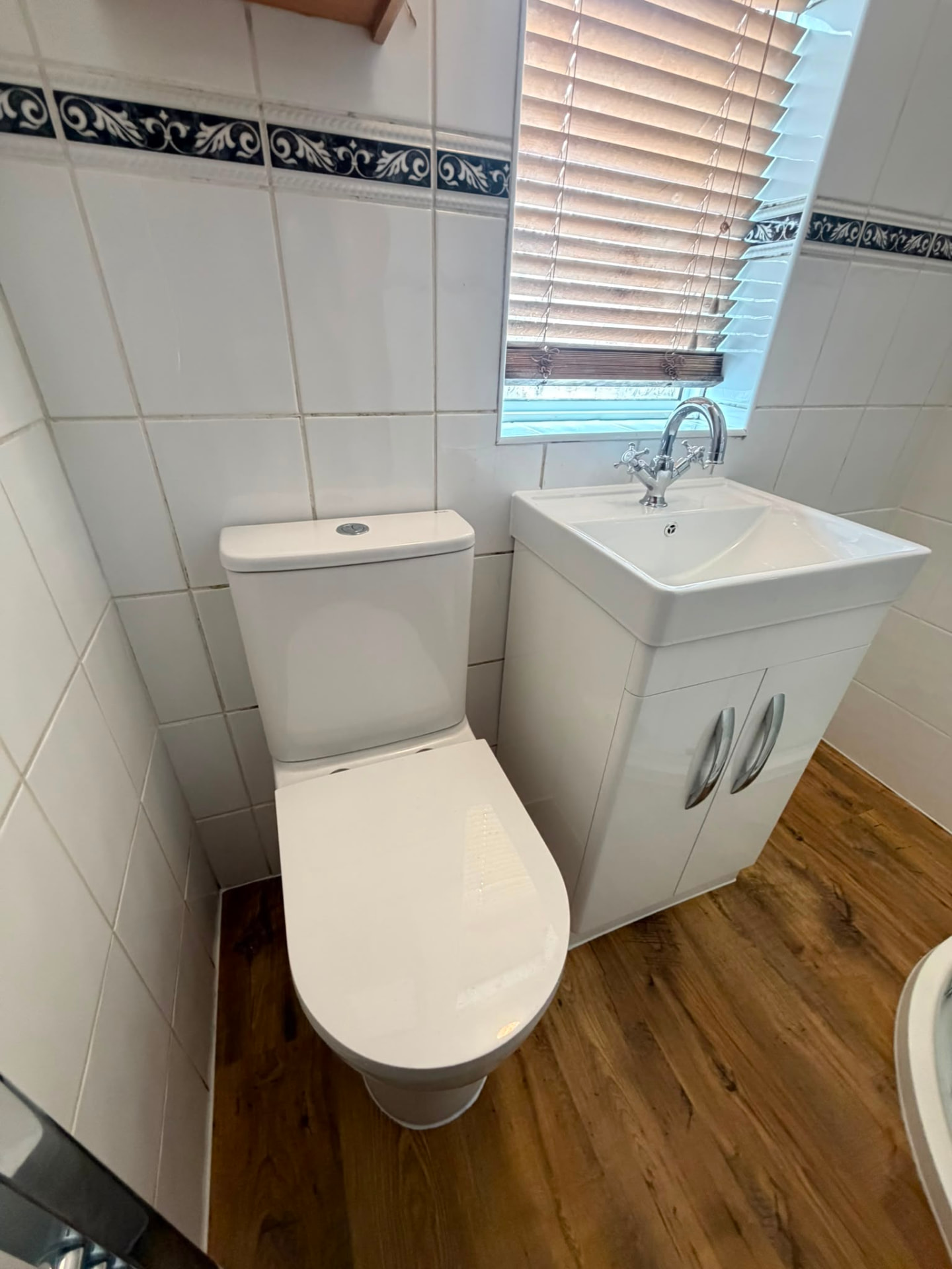 New close-coupled toilet and white vanity unit basin with chrome mixer tap fitted in tiled cloakroom, Coventry